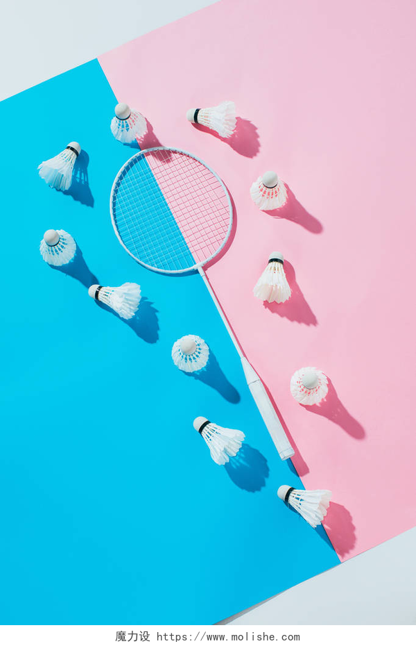 粉蓝相间的地板上有着一个球拍和羽毛球蓝色和粉红色的纸羽毛球周围的羽毛球拍的顶部视图